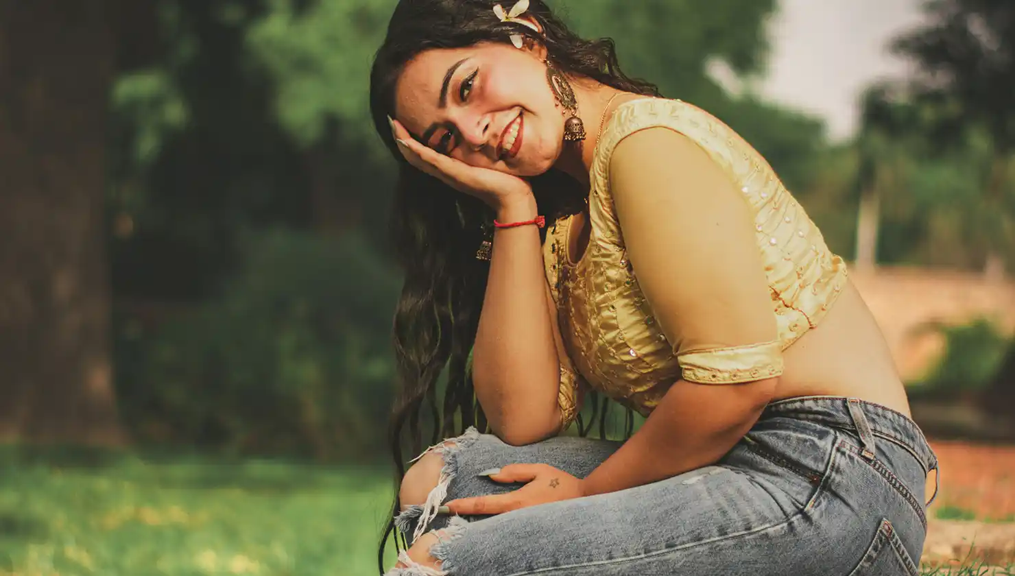 Possible breast reduction candidate - happy woman sitting hunched as if trying to disguise the size of her breasts.