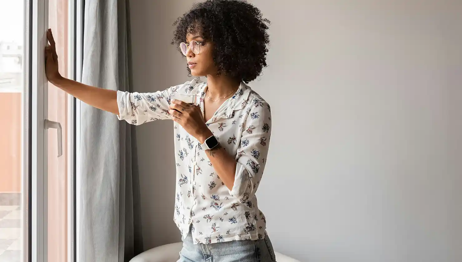 Potential breast augmentation patient considering a decision while looking out a window