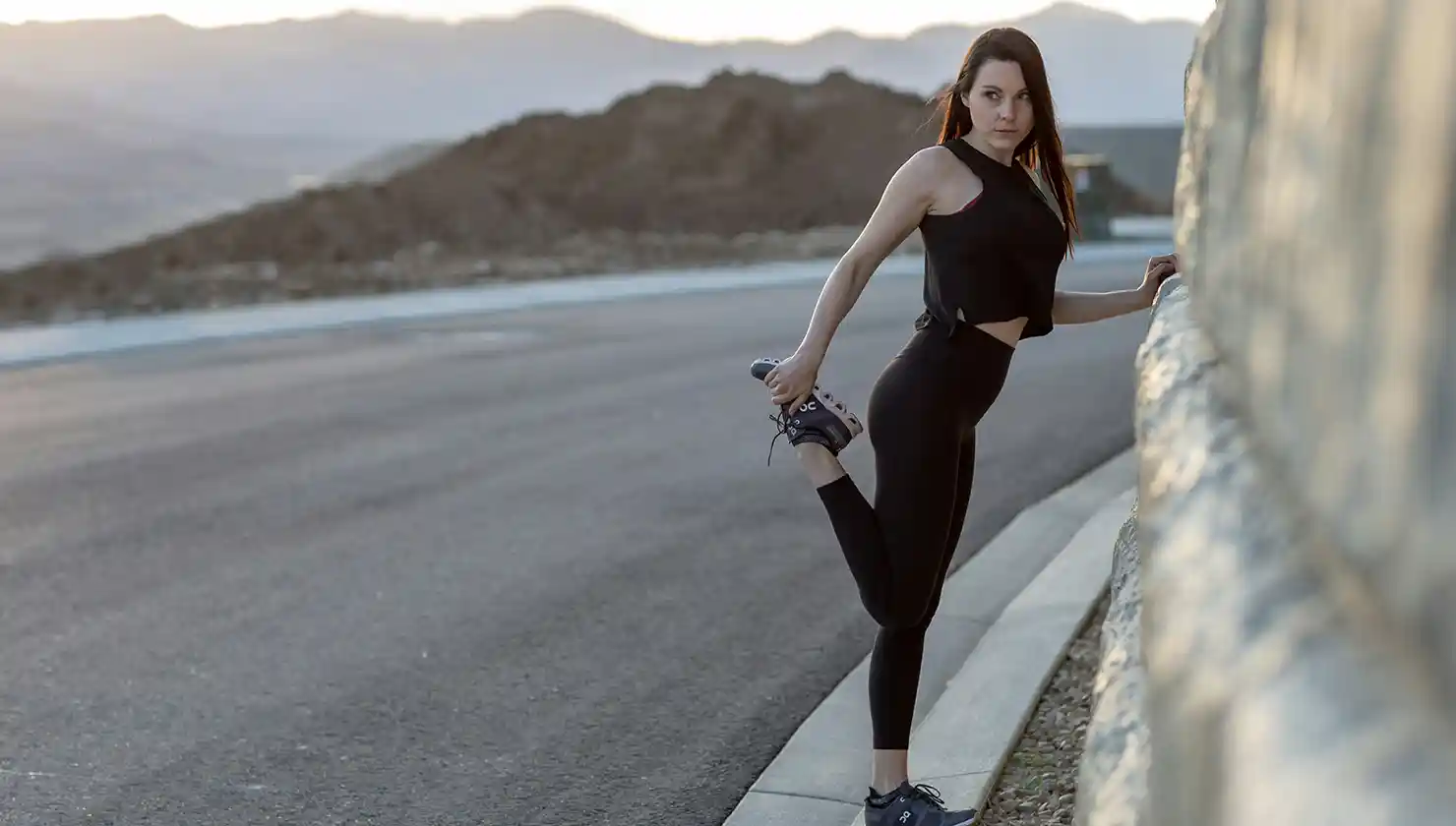 woman stretching before a mountain run - potential patient for Preservé breast augmentation, looking to get back to fitness routine faster than traditional breast augmentation - wants quick-recovery boob job